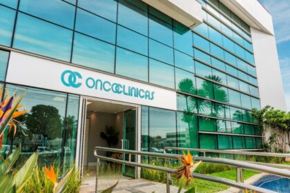 Sede da Oncoclínicas com gráfico financeiro ao fundo representando reestruturação de dívida de R$ 5,7 bi