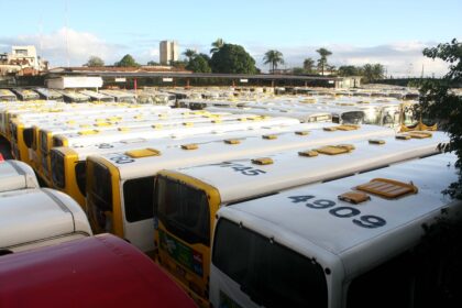 Fileira de ônibus municipais estacionados em garagem de Salvador durante eleições 2026