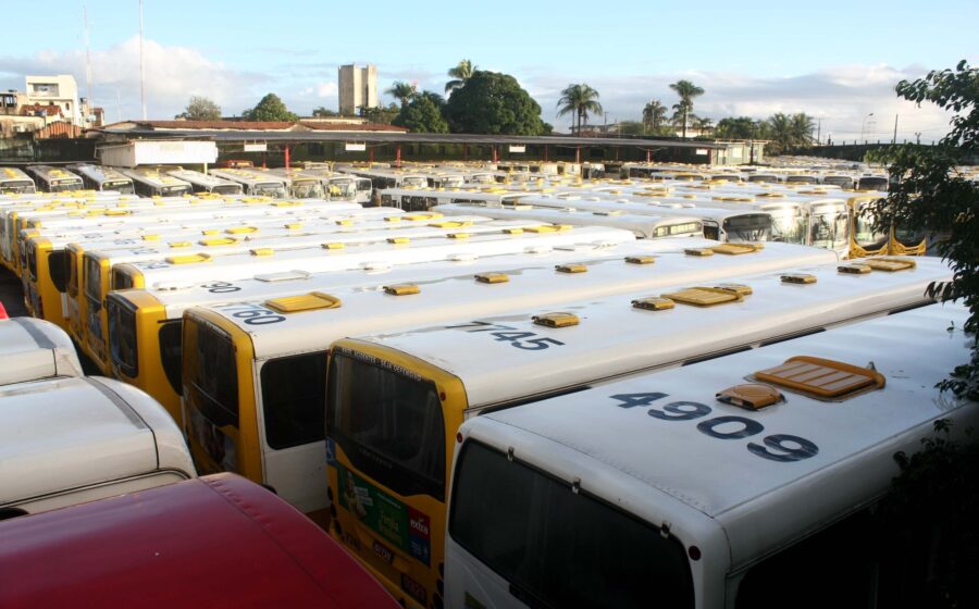 Fileira de ônibus municipais estacionados em garagem de Salvador durante eleições 2026