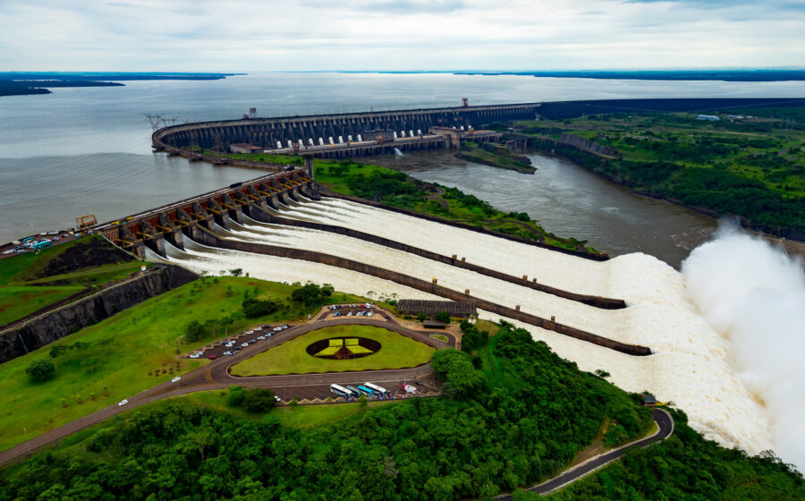 Usina de Itaipu com servidores de IA em primeiro plano, simbolizando disputa por energia entre Brasil e Paraguai