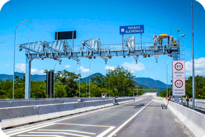 Gantry de pedágio free flow na Dutra com caminhões e carros nas pistas expressas