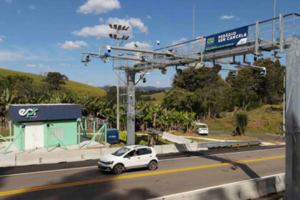 Governador em celular diante de obra parada e estrada sem pedágio