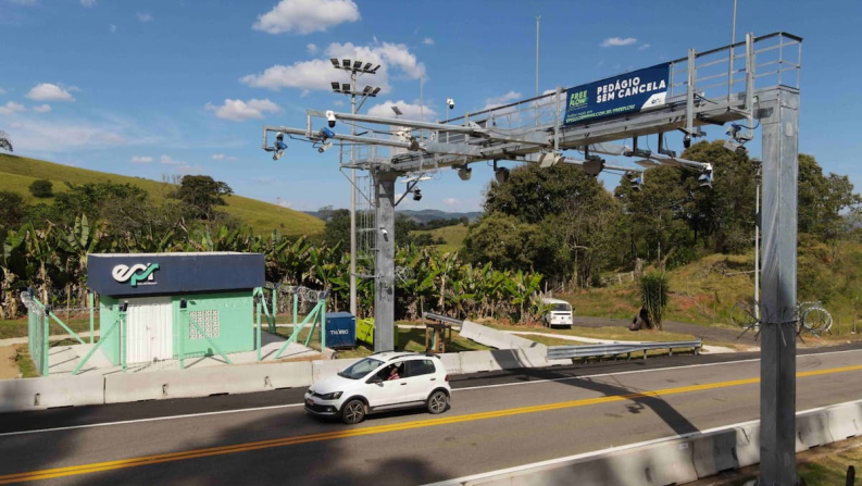 Governador em celular diante de obra parada e estrada sem pedágio