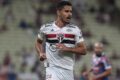 Ruan Tressoldi em ação pelo São Paulo segurando o joelho direito lesionado durante partida