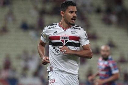 Ruan Tressoldi em ação pelo São Paulo segurando o joelho direito lesionado durante partida