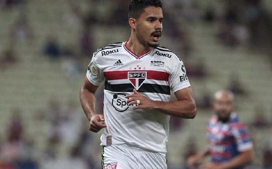 Ruan Tressoldi em ação pelo São Paulo segurando o joelho direito lesionado durante partida