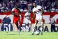 Ruan Tressoldi com camisa do São Paulo segurando joelho direito lesionado