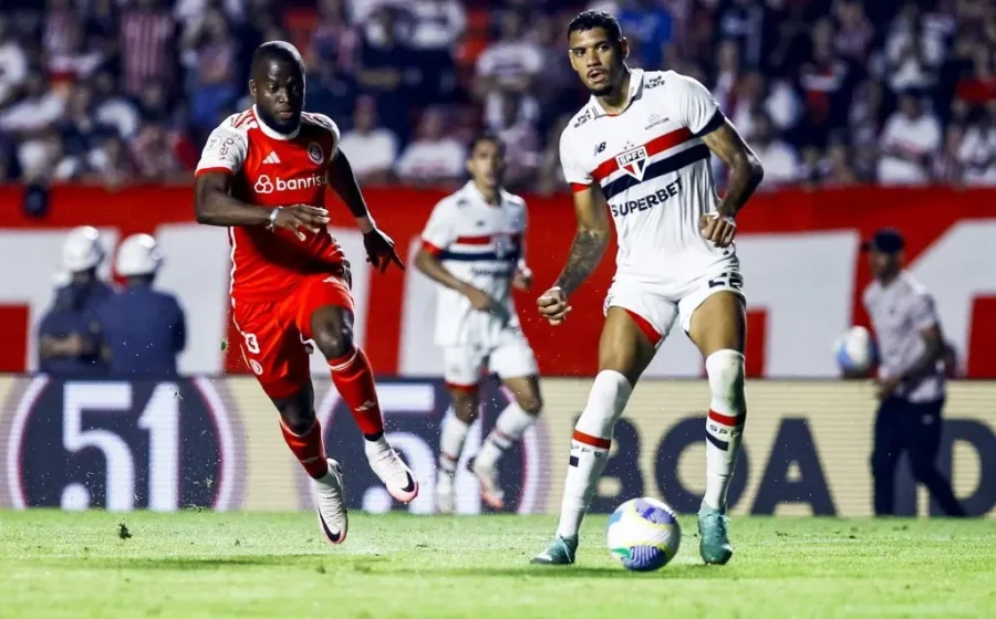 Ruan Tressoldi com camisa do São Paulo segurando joelho direito lesionado