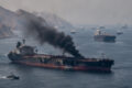 Gráfico de alta do petróleo Brent com silhueta de petroleiros no Estreito de Hormuz ao fundo