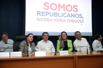 Praia urbana movimentada com calçadão e quiosques, representando gestão municipal litorânea