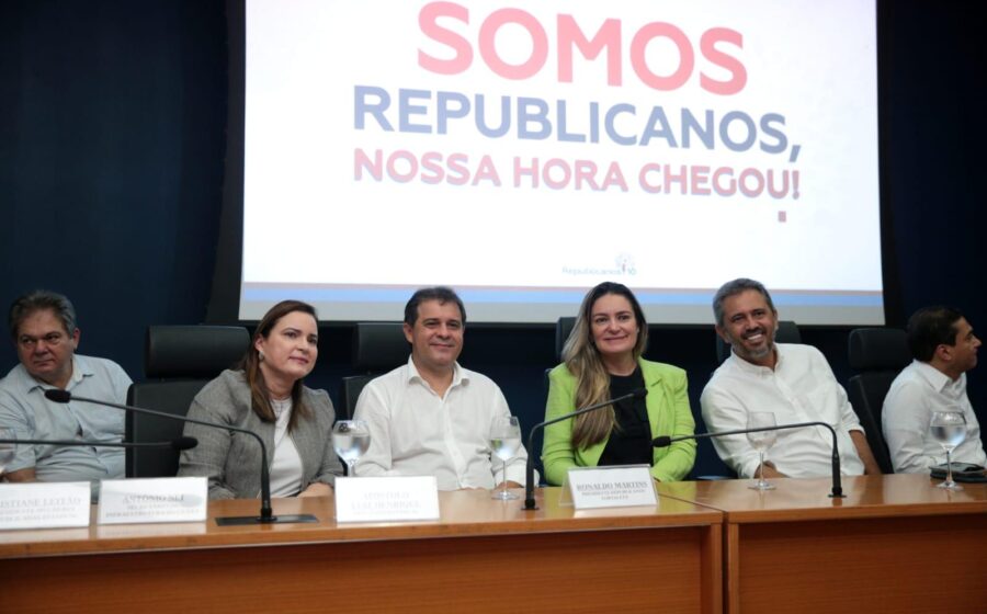 Praia urbana movimentada com calçadão e quiosques, representando gestão municipal litorânea