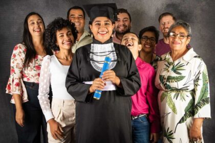 Formando de primeira geração segurando diploma, simbolizando ascensão salarial após faculdade particular