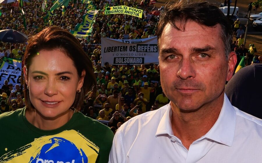 Flávio Bolsonaro discursa com bandeira do Brasil ao fundo, simbolizando racha na direita