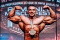 Rafael Brandão em pose de fisiculturismo, transição da categoria Open para Classic Physique