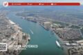 Vista aérea do Porto de Santos com navios e contêineres sob chuva intensa, recordando recorde histórico e queda em setembro
