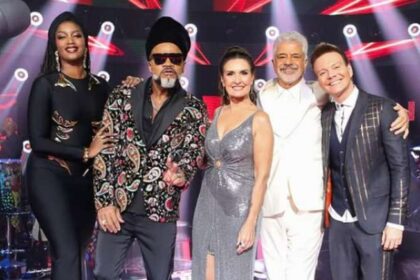 Logotipo do The Voice Brasil sobre fundo de urna eletrônica e calendário marcando 26 de outubro