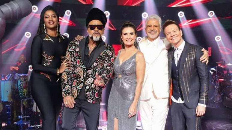Logotipo do The Voice Brasil sobre fundo de urna eletrônica e calendário marcando 26 de outubro