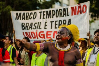 Indígenas em barco rumo a local de votação na Amazônia, com risco de exclusão por regra do TSE