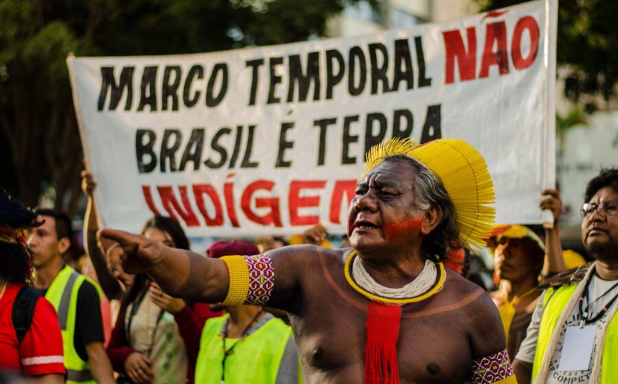 Indígenas em barco rumo a local de votação na Amazônia, com risco de exclusão por regra do TSE
