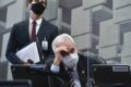 Senador Flávio Bolsonaro em destaque com bandeiras do Brasil e EUA ao fundo, representando crise institucional e risco país