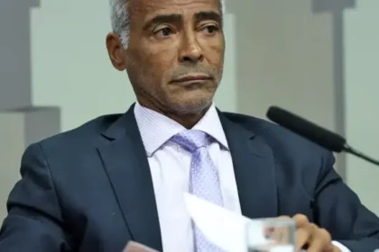Senador Flávio Bolsonaro com bandeira dos EUA e símbolo de salário cortado, representando fuga e ação judicial
