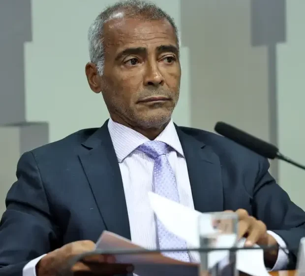 Senador Flávio Bolsonaro com bandeira dos EUA e símbolo de salário cortado, representando fuga e ação judicial