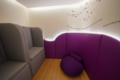Sala sensorial em shopping com iluminação suave, puffs coloridos e painéis interativos para autistas