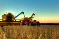 Plantação de soja extensiva no Brasil com máquinas agrícolas colhendo grãos