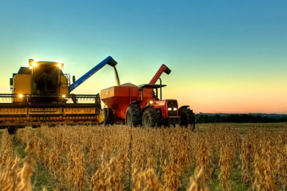 Plantação de soja extensiva no Brasil com máquinas agrícolas colhendo grãos