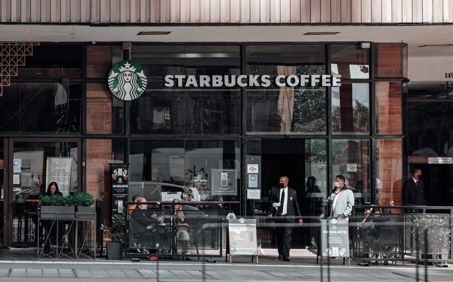 Logos da Starbucks e Chipotle lado a lado com setas indicando fusão bilionária