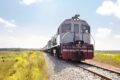 Trilhos da ferrovia Transnordestina no sertão nordestino com paisagem árida ao fundo