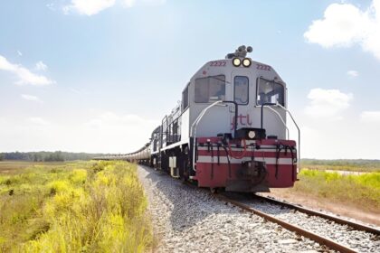 Trilhos da ferrovia Transnordestina no sertão nordestino com paisagem árida ao fundo