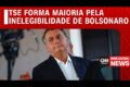 Ministro do TSE analisa celular com ícone do WhatsApp e martelo judicial sobre mesa