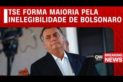 Ministro do TSE analisa celular com ícone do WhatsApp e martelo judicial sobre mesa