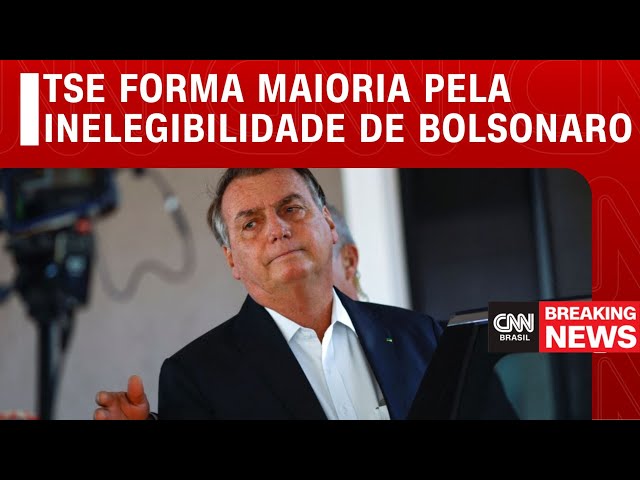 Ministro do TSE analisa celular com ícone do WhatsApp e martelo judicial sobre mesa