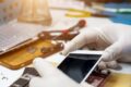 Técnico de assistência técnica acessando dados privados em smartphone durante reparo