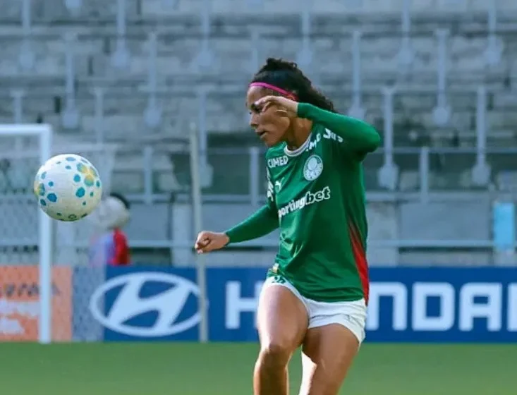 Escudos de Bahia, Palmeiras e São Paulo sobre fundo de estádio com taça de premiação de futebol feminino