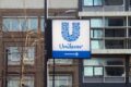 Produtos Unilever em prateleira de supermercado com etiquetas de preço em destaque