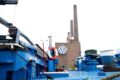 Funcionários da Volkswagen em linha de montagem com gráficos de salários congelados até 2030