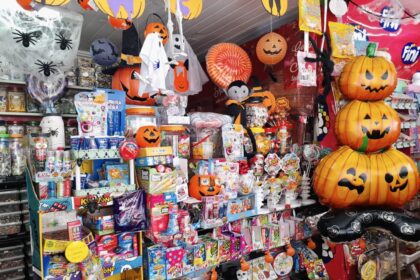 Doces decorados de Halloween em vitrine de confeitaria de Ribeirão Preto com abóboras, fantasmas e cores laranja e roxo