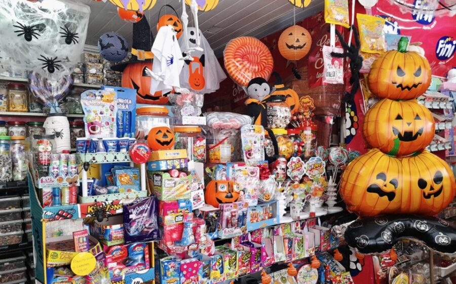 Doces decorados de Halloween em vitrine de confeitaria de Ribeirão Preto com abóboras, fantasmas e cores laranja e roxo