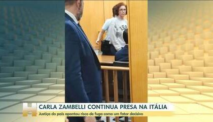 Carla Zambelli em tribunal italiano com bandeiras do Brasil e Itália ao fundo, simbolizando disputa de extradição