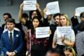 Mulher em frente ao Senado Federal segurando tablet com interface de IA generativa representando relacionamento humano-máquina