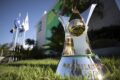 Escudos de Grêmio, Inter e Corinthians sobre tabela de rebaixamento do Brasileirão com gestores caóticos ao fundo