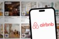 Passageiro em aeroporto reservando hospedagem alternativa pelo celular após voo cancelado
