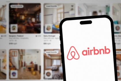 Passageiro em aeroporto reservando hospedagem alternativa pelo celular após voo cancelado
