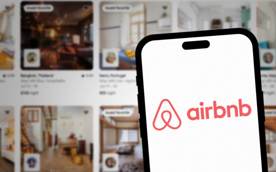 Passageiro em aeroporto reservando hospedagem alternativa pelo celular após voo cancelado