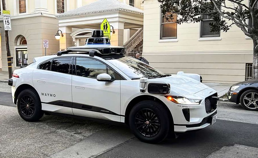 Robotáxi Waymo autônomo circulando em cidade americana, representando frota com 95% menos acidentes graves