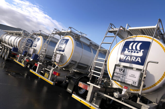 Fábrica da Yara com silos de fertilizantes e chamas de gás natural ao fundo